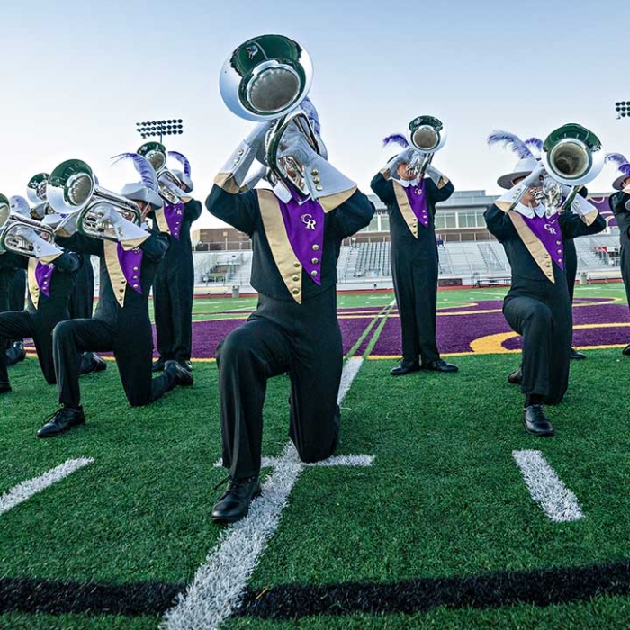 Marching band posing on a football field.